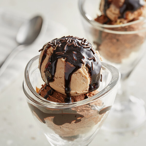 A glass cup with a scoop of Oringer Milk Fudge Dessert and chocolate syrup.