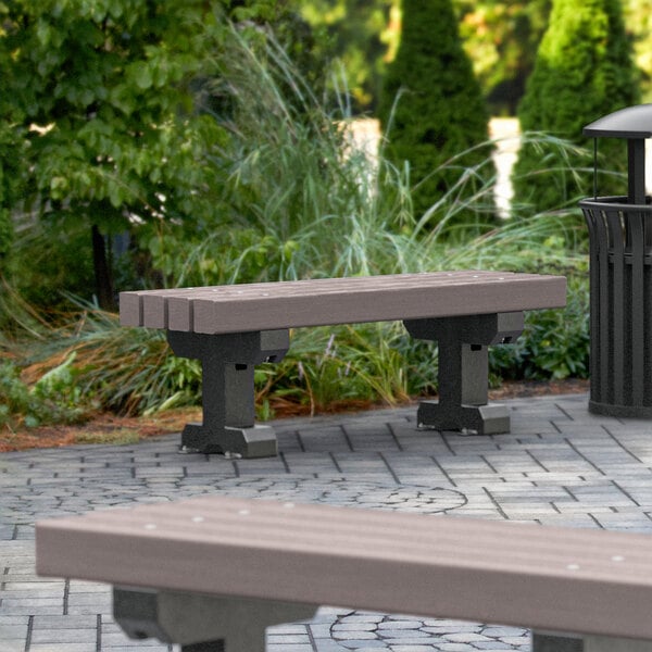 A brown MasonWays plastic Dura-Bench with black legs in a park.