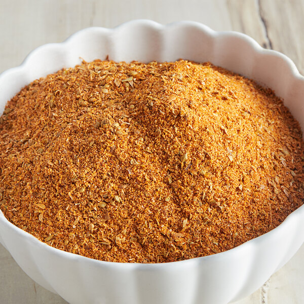 A bowl of McCormick Culinary Cajun seasoning on a wooden table.