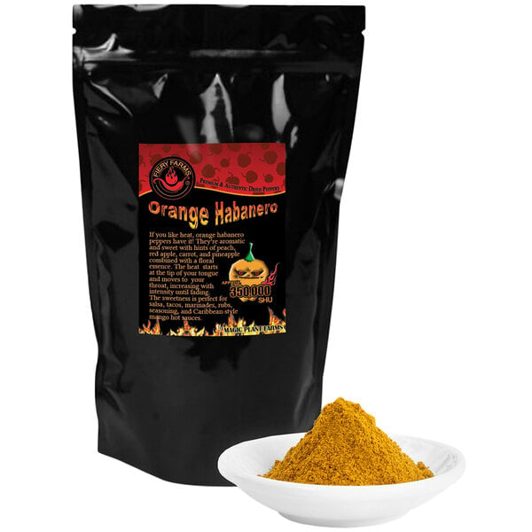 A black bag of Fiery Farms Orange Habanero Pepper Powder on a counter next to a bowl of yellow powder.