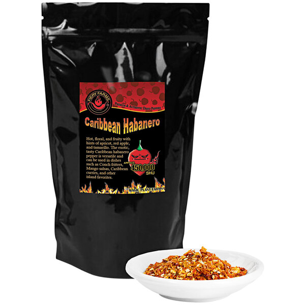 A black bag of Fiery Farms Red Caribbean Habanero Pepper Flakes with a white bowl of crushed red peppers.