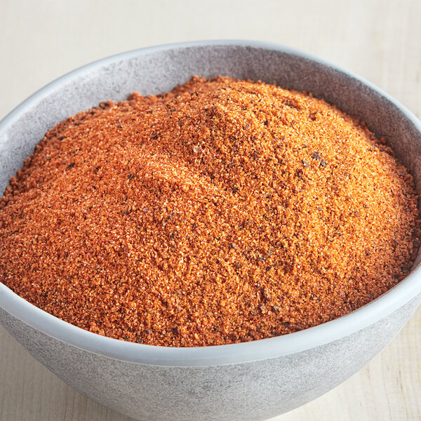 A bowl of red and orange McCormick Culinary Rotisserie Chicken seasoning.