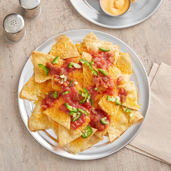 A Choice aluminum serving platter with a plate of nachos, salsa, and cheese.