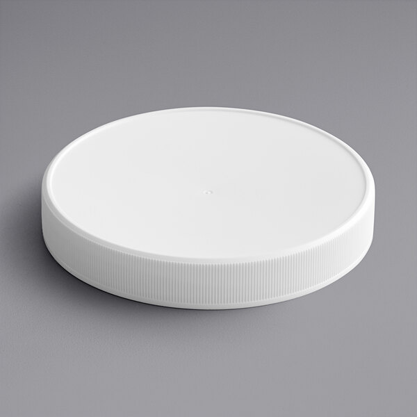 A 120/400 white plastic cap with a foam liner on a gray surface.