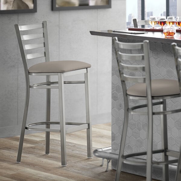 Lancaster Table & Seating Clear Coat Finish Ladder Back Bar Stool with 2 1/2" Dark Gray Vinyl Padded Seat