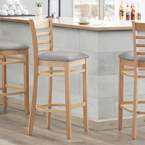 Lancaster Table & Seating Natural Finish Wooden Ladder Back Bar Height Chair with Light Gray Padded Seat