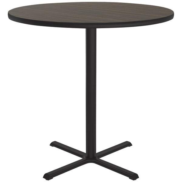 A Correll round bar height table with a walnut finish top and black base.