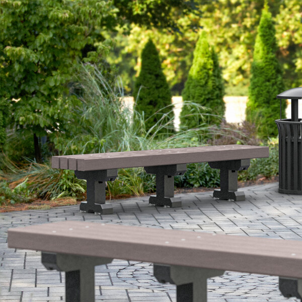 A brown MasonWays plastic Dura-Bench with black legs in a park.