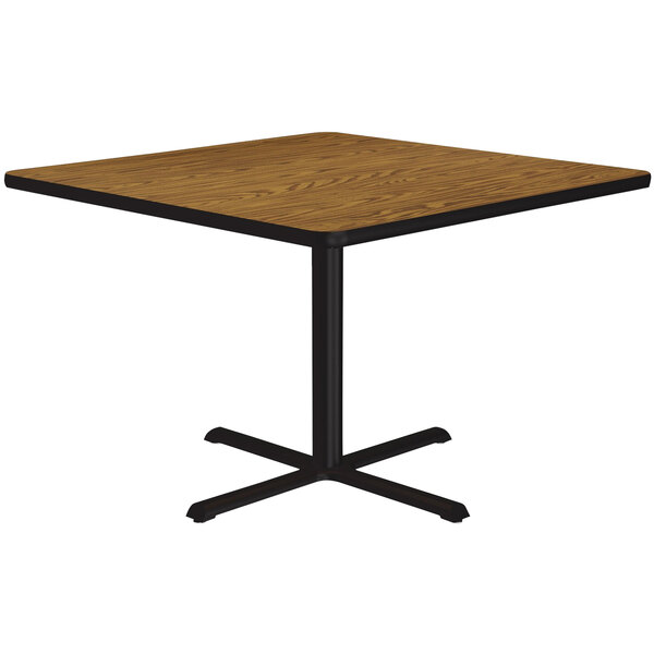 A Correll square table with a black base and a wooden top.