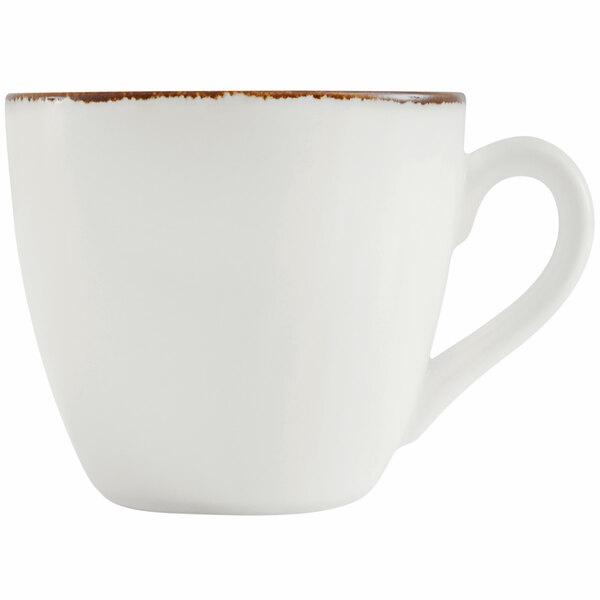 A close-up of a Fortessa bright white espresso cup with brown speckles on the rim.