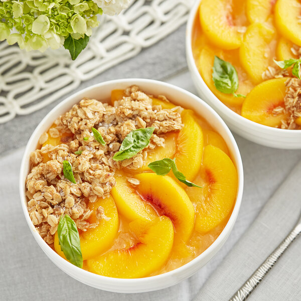 A bowl of oatmeal topped with sliced peaches and a bowl of sliced peaches.
