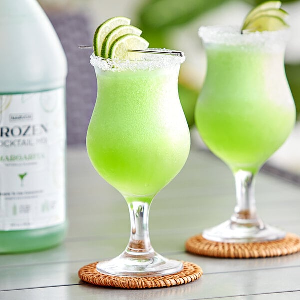 Two glasses of Narvon Margarita frozen cocktail mix with lime slices.