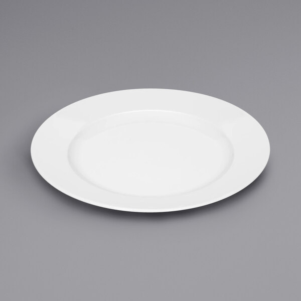 A Bauscher bright white porcelain plate with a white rim on a gray surface.