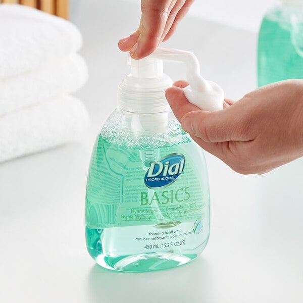 A person using a pump bottle of Dial Hypoallergenic Foaming Hand Wash.