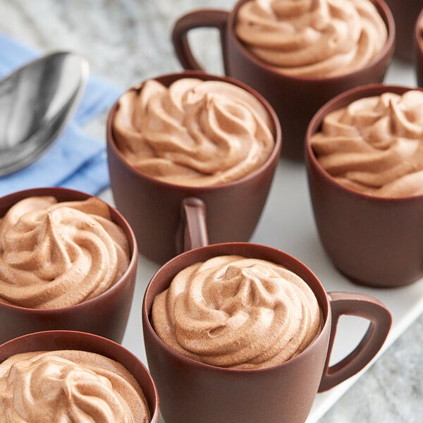 A group of cups of Callebaut milk chocolate mousse with spoons.