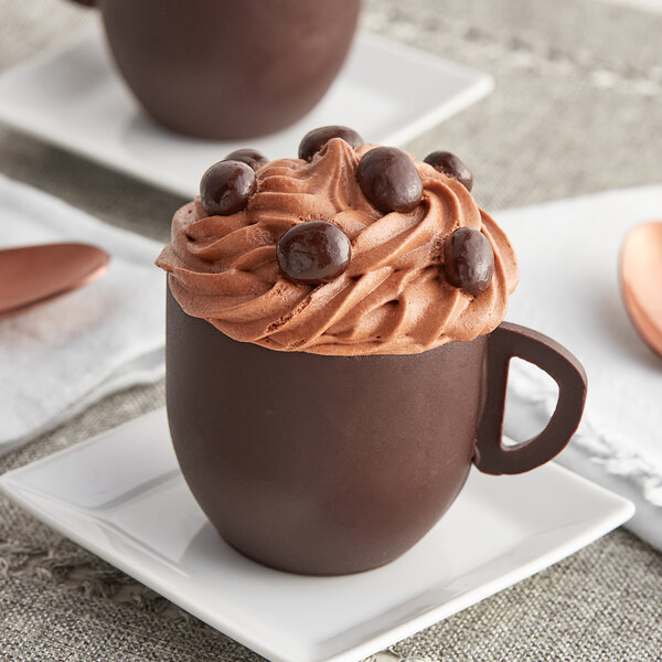 Two Mona Lisa chocolate coffee cups filled with chocolate mousse and chocolate chips.