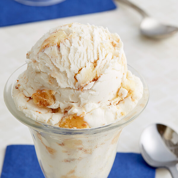 A glass cup with a scoop of ice cream topped with Baked Cheesecake Pieces.