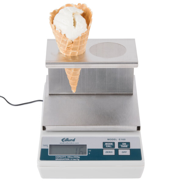 An Edlund digital portion scale with an ice cream cone platform on top weighing a waffle cone with a scoop of ice cream.