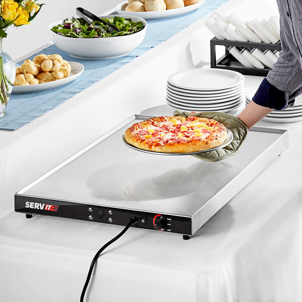 A hand using a ServIt heated shelf to hold a pizza.