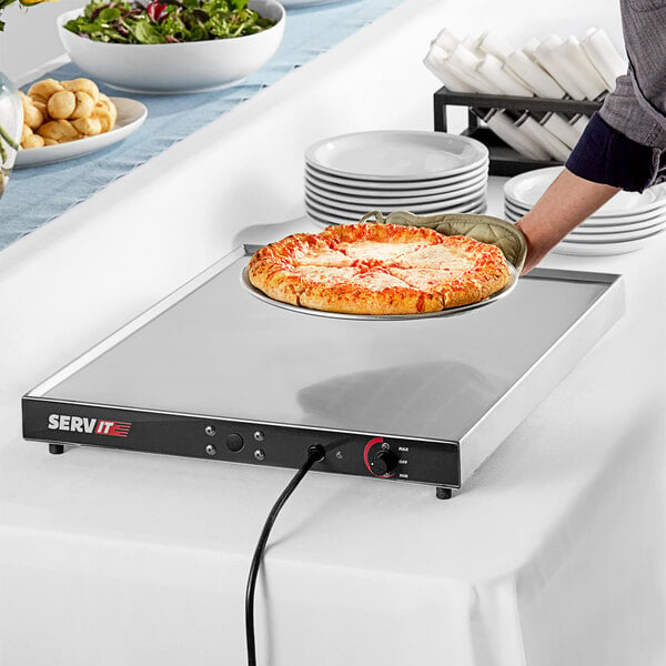 A person holding a pizza on a ServIt heated shelf.