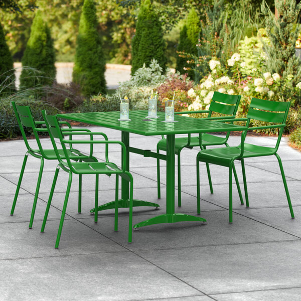 A green table and chairs on a patio.