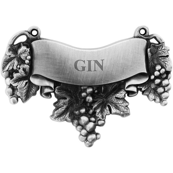A silver metal Franmara decanter label with an engraved "gin" label and grape and leaf details.