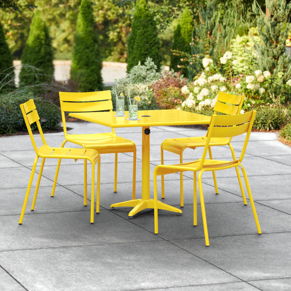 A yellow table and chairs on a patio.
