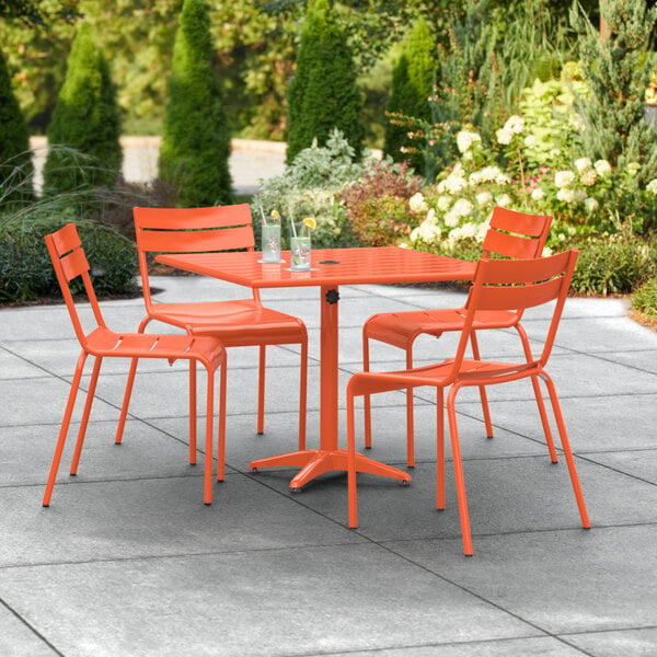 An orange table and chairs on a patio.