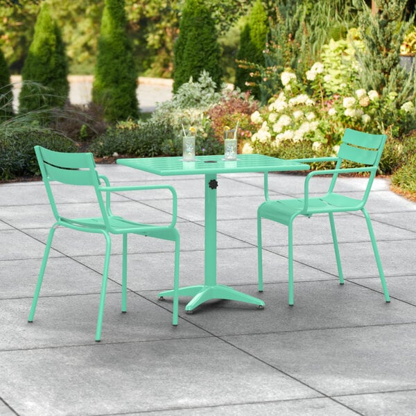 A Lancaster Table & Seating seafoam green table and chairs on an outdoor patio.