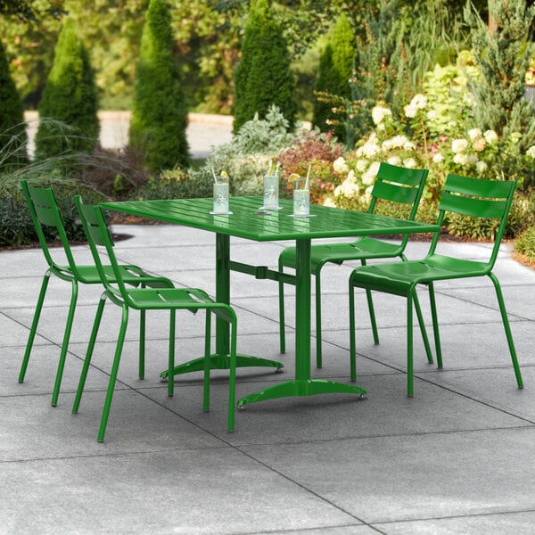 A green table with chairs on an outdoor patio.