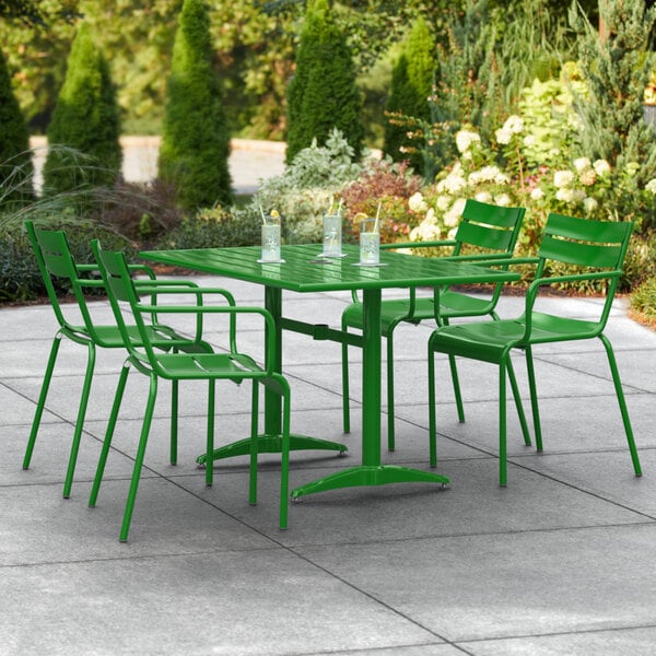 A green metal table and chairs on a patio.