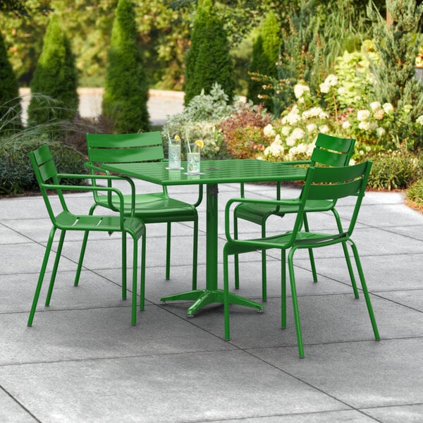 A green metal table and chairs on an outdoor patio.