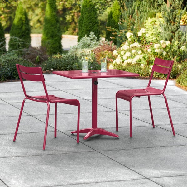 A red outdoor table with chairs on a patio.