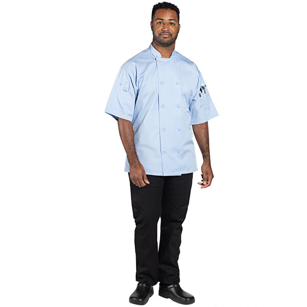 A man wearing a sky blue Uncommon Chef short sleeve chef coat.