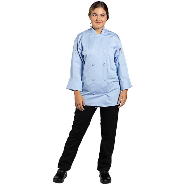 A woman wearing a sky blue Uncommon Chef long sleeve chef coat.