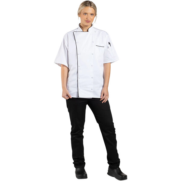 A woman wearing a Uncommon Chef white chef coat with black piping.