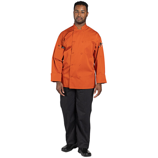 An Uncommon Chef Pulse orange long sleeve chef coat on a counter.
