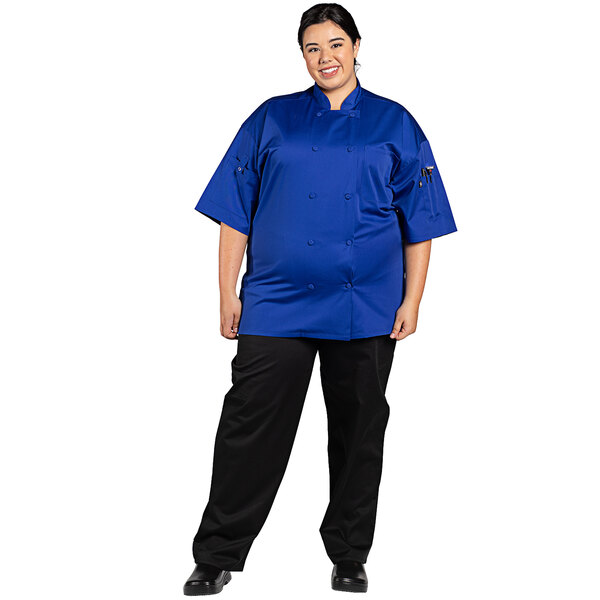 A woman wearing a deep royal blue Uncommon Chef Resilience chef coat.