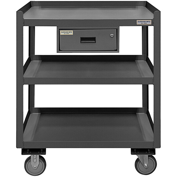 A grey metal Durham shop desk with 3 shelves and a drawer on wheels.