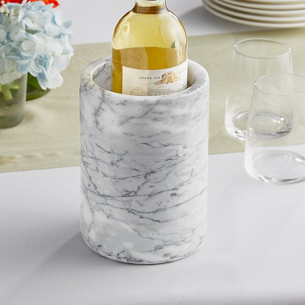 A white marble wine cooler holding a bottle of wine.