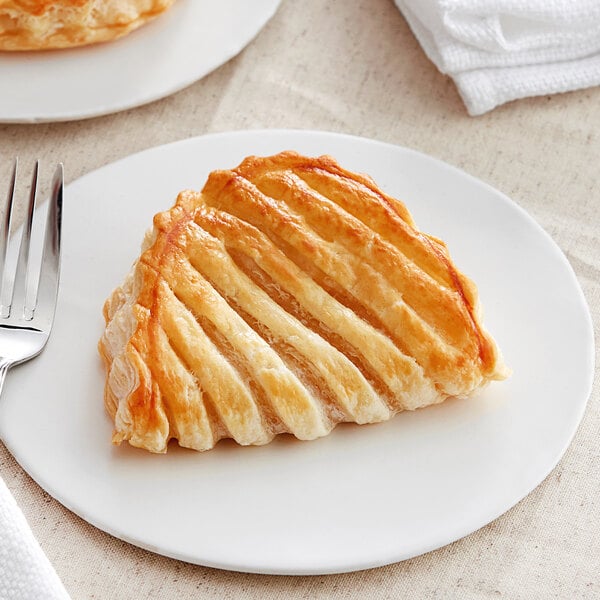 A white plate with two White Toque apple turnovers on it.