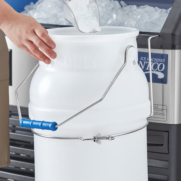 A hand using a Choice stainless steel filling hanger to pour ice into a bucket.