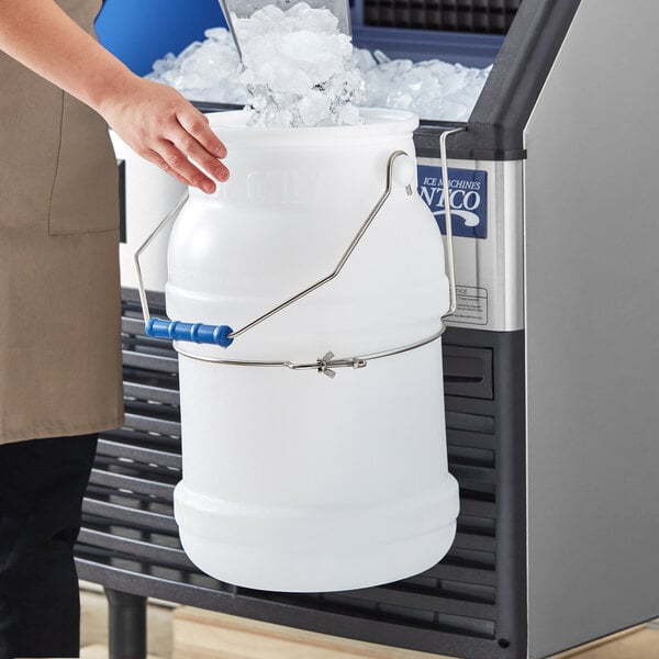 A person holding a Choice 5 gallon polypropylene ice bucket full of ice with a lid.