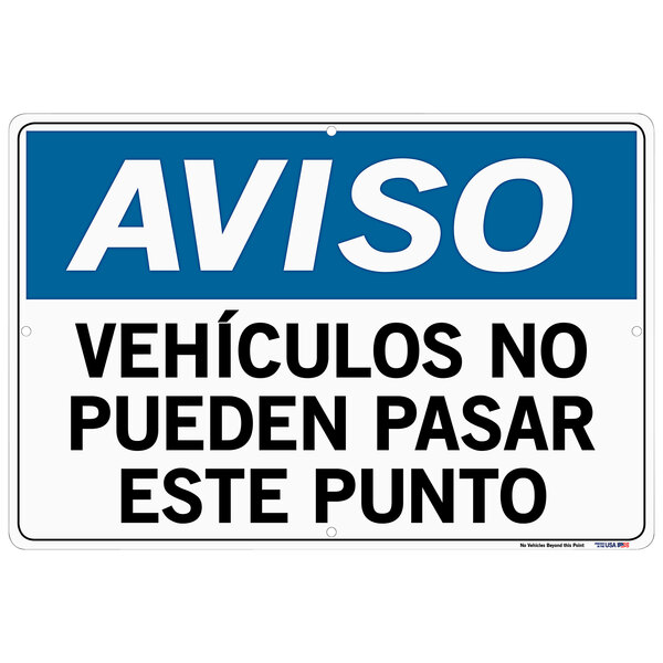A blue and white Vestil aluminum composite sign that says "Aviso / Vehículos No Pueden Pasar Esta Punto" in black text.