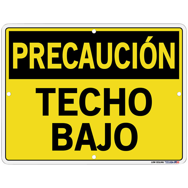 A yellow Vestil Polystyrene sign with black Spanish text that says "Precauci&#243;n / Techo Bajo" on a white background.