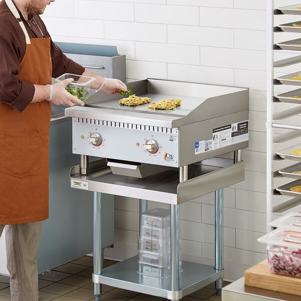 A man in an apron cooking food on a Cooking Performance Group electric countertop griddle.