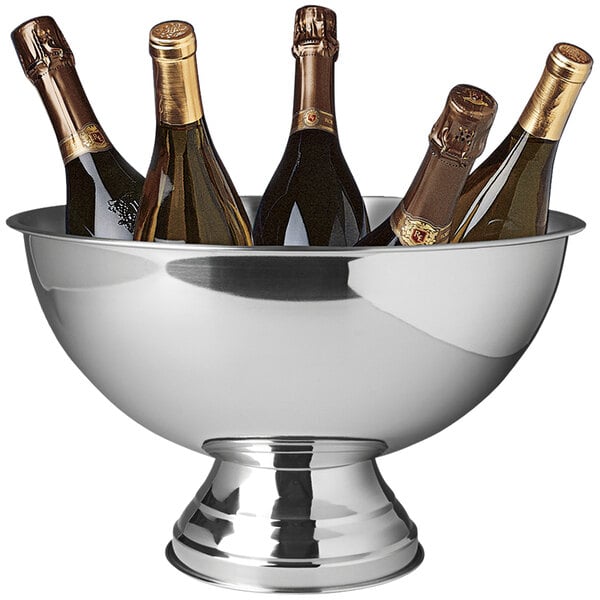 A Franmara stainless steel catering bowl filled with bottles of champagne on a table.