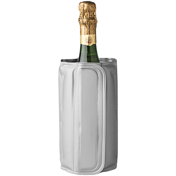 A bottle of champagne in a white wine chiller sleeve on a table.
