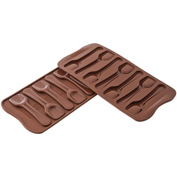 A brown Silikomart silicone chocolate mold with spoons.