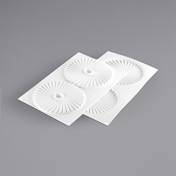 A white silicone mold with spiral designs in the center.